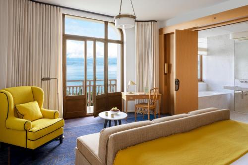ein Wohnzimmer mit einem Sofa und einem gelben Stuhl in der Unterkunft Hôtel Royal in Évian-les-Bains