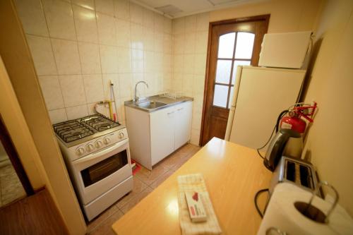 a small kitchen with a stove and a sink at Departamento las Torres in Punta Arenas