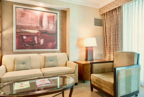 a living room with a couch and a table at Strip View Balcony Suites - No Resort Fee ! in Las Vegas