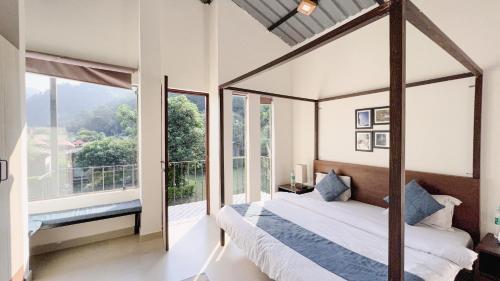 Schlafzimmer mit Himmelbett und großen Fenstern in der Unterkunft Aspen Adventures Camp by Aspen in Rishikesh