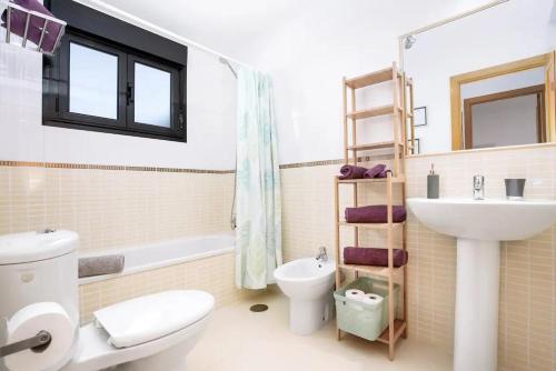 a bathroom with a white toilet and a sink at Villardilla Fuerteventura in La Oliva