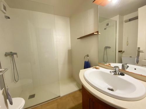 a bathroom with a sink and a shower with a mirror at Maravilloso apartamento PRIMERA LINEA DE MAR in L'Escala