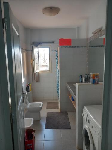 bagno con lavandino e servizi igienici e lavatrice. di Casa Kassi a Ndéyane