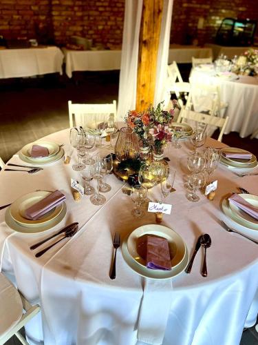 a table with a white table cloth with plates and glasses at Penzion POSADA in Podivín