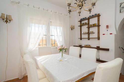 a white table with white chairs and a vase of flowers on it at Casa Coral Spaniahome in Alfaz del Pi