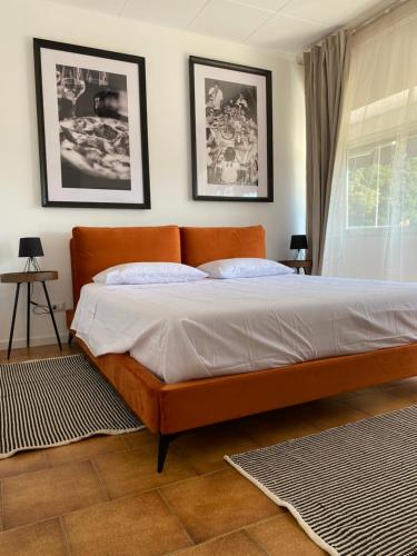 1 cama en un dormitorio con 2 cuadros en la pared en THE BEACH - large apartment with private beach, en Pettenasco