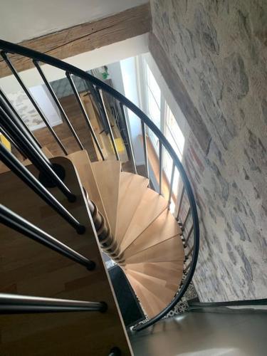 a spiral staircase in a building with a window at La maisonnette de la gare in Montmartin-sur-Mer