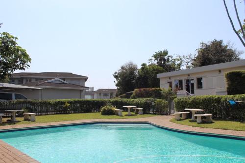 a swimming pool in front of a house at 4 Boboyi - Mangrove Beach Estate in Port Shepstone