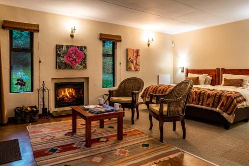una camera da letto con un letto e un camino di Kuhestan Farm Cottages a Haenertsburg