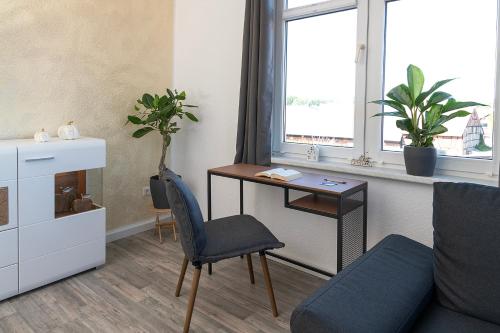 a living room with a desk and a chair at Ilmpartment - Vollausstattung - Boxspringbett - Wi-Fi - Netflix in Ilmenau