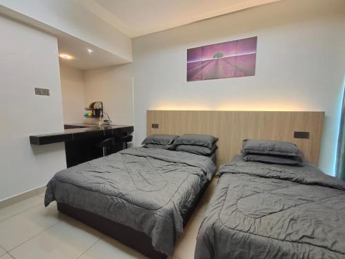 1 dormitorio con 2 camas, escritorio y encimera en Alish Studio Apartment with Pool, Netflix, Wifi, en Gua Musang