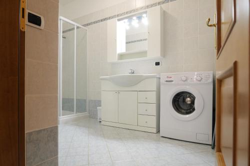 a bathroom with a washing machine and a sink at CASA NAVLA' AppartamentI "Ulivi"- "Fiori" -"Velieri"-"Luna"-"Nido"-"Taverna" in Tignale