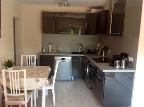 une petite cuisine avec une table et une table et des chaises dans l'établissement Appartement charmant à Fréjus, 40 m², proche du jardin, à Fréjus