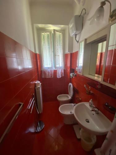 a red bathroom with two toilets and a sink at GELSOMINO in Levanto