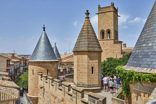 a group of people walking around a castle with turrets at Apartamentos Ribera Navarra - Bardenas in Castejón