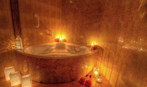 a bathroom with a tub with candles in it at Jaś Wędrowniczek in Rymanów