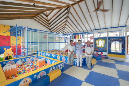 a group of three people standing in a play room at Joy Island Maldives All Inclusive Resort in Male City