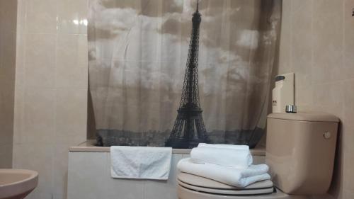 a bathroom with a toilet and the eiffel tower at Albergue Tritón - Villanúa in Villanúa