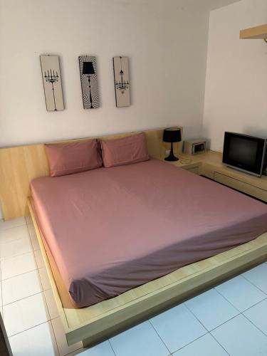 a large bed in a room with a tv at Urban Patong Residence in Patong Beach