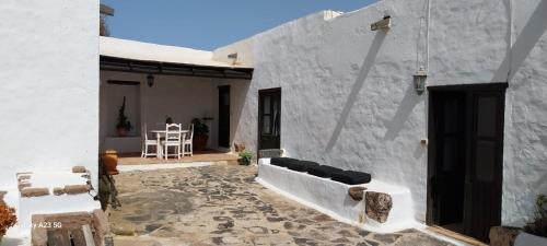 Ein weißes Haus mit einer Terrasse und einem Tisch in der Unterkunft Suite casa rural Los Patios, CONIL in Tías