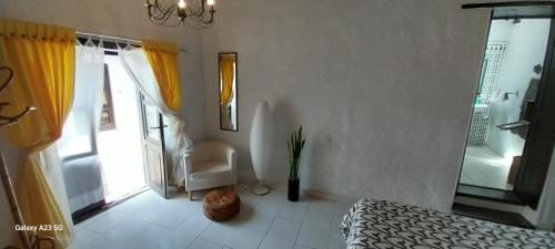 een slaapkamer met een bed, een raam en een stoel bij Suite casa rural Los Patios, CONIL in Tías