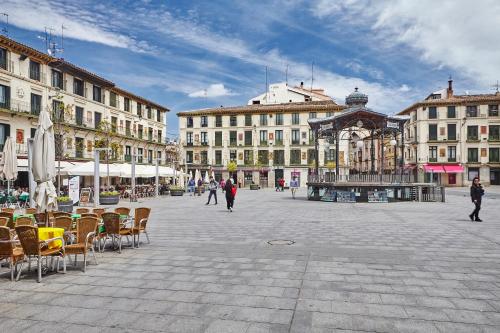 a city square with chairs and tables and buildings at Apartamentos Ribera Navarra - Bardenas in Castejón