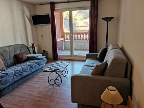 un salon avec deux canapés et une table dans l'établissement Appartement confort 8 pers, 2 chambres, terrasse, buanderie, près des pistes - FR-1-404-146, à La Mongie
