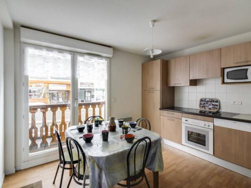une cuisine avec une table et des chaises ainsi qu'une fenêtre dans l'établissement Appartement confort 8 pers, 2 chambres, terrasse, buanderie, près des pistes - FR-1-404-146, à La Mongie