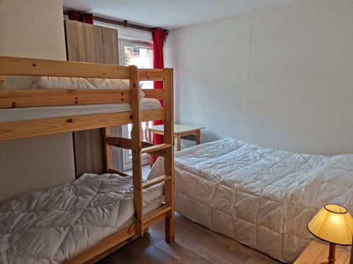 une chambre avec deux lits superposés et une lampe dans l'établissement Appartement confort 8 pers, 2 chambres, terrasse, buanderie, près des pistes - FR-1-404-146, à La Mongie