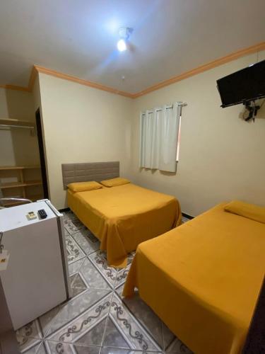 a hotel room with two beds and a tv at Casarão Hotel Pousada in São Luís