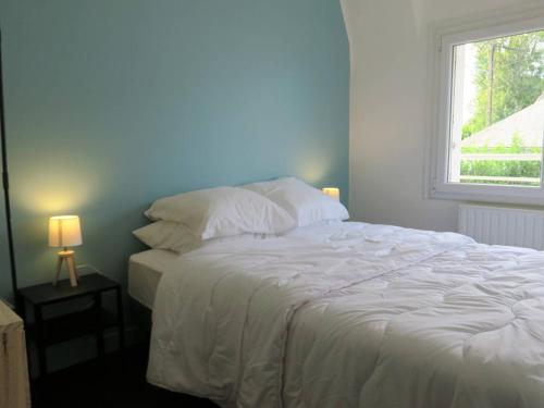 une chambre avec un grand lit blanc avec une fenêtre dans l'établissement Maison cosy 5 pers à 640m de la plage et proche GR34 à Perros-Guirec - FR-1-368-309, à Perros-Guirec