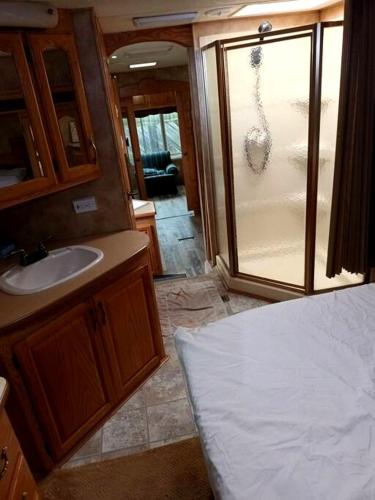 a bathroom with a sink and a glass shower at 40' RV Move in Ready in Jordan