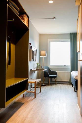 a bedroom with a bed and a desk and a chair at Hotell Nyboholm in Ulricehamn