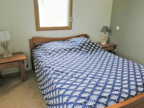 - un lit avec une couette bleue et blanche dans une chambre dans l'établissement Maison à Trégastel : WIFI, jardin, terrasse sud, proche plage, calme - FR-1-368-333, à Trégastel