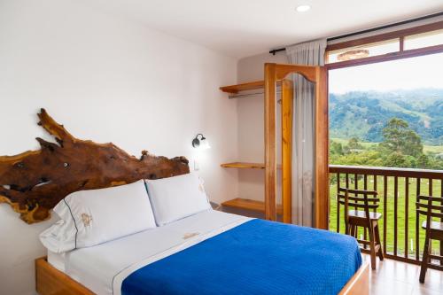 1 dormitorio con 1 cama y balcón con vistas. en Hospedaje Vista Hermosa Salento, en Salento