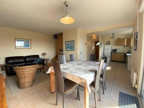 une salle à manger et un salon avec une table et des chaises dans l'établissement Maison 3* face à la mer avec WiFi, à 200m du littoral, terrasse, parking, et tout confort à Pleumeur-Bodou - FR-1-368-366, à Pleumeur-Bodou