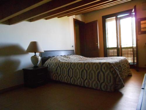 een slaapkamer met een bed met een lamp en een raam bij B&B Castellazzo in Paceco