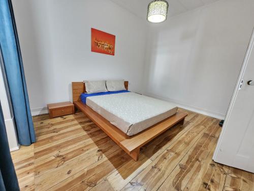 1 dormitorio con 1 cama y suelo de madera en Casa Semedo, en Montemor-o-Novo