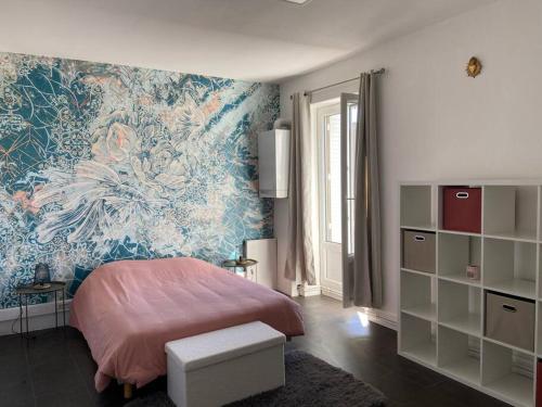 une chambre avec un lit et une peinture murale dans l'établissement La maison bleue, à Montcenis