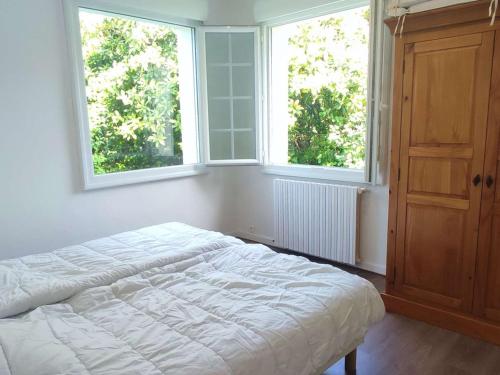 - une chambre avec un lit blanc et 2 fenêtres dans l'établissement Grande Maison Familiale à Trégastel avec Jardin Clos, Terrasse et WIFI - FR-1-368-393, à Trégastel