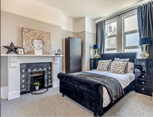 a bedroom with a bed and a fireplace at Debenham Lodge Margate in Kent