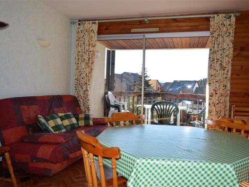un salon avec une table et un canapé dans l'établissement Appartement cosy 2 pièces, terrasse ensoleillée, skis aux pieds, animaux acceptés, Bolquère - FR-1-592-59, à Bolquère-Pyrénées 2000
