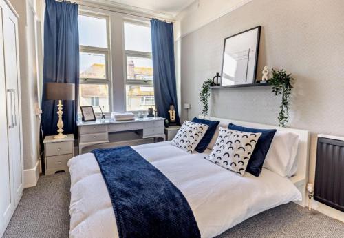 a bedroom with a large bed with blue and white pillows at Debenham Lodge Margate in Kent