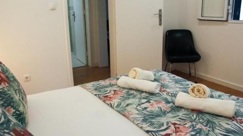 a room with a bed with towels and a chair at A m a r - 450m from the beach in São Roque