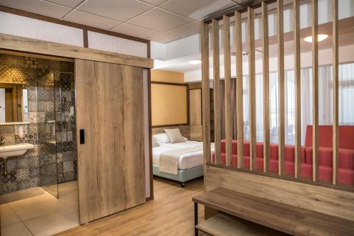a hotel room with a bed and a bathroom at Hotel Delfin in Izola