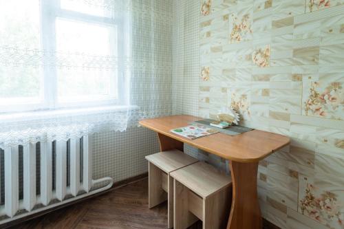 a small room with a wooden table and a window at Дуглас in Petropavlovsk