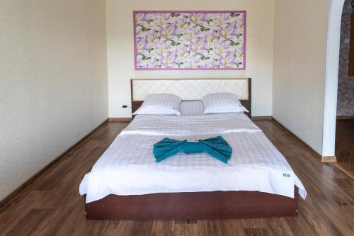 a bedroom with a bed with a bow tie on it at Дуглас in Petropavlovsk