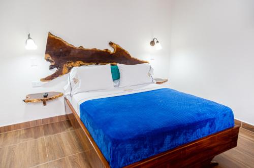 a bedroom with a bed with a blue blanket at Hospedaje Vista Hermosa Salento in Salento