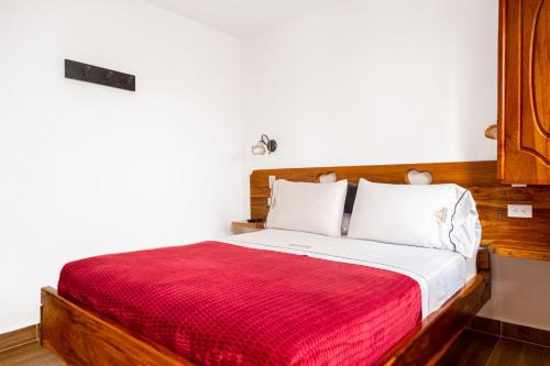 a bedroom with a bed with a red blanket at Hospedaje Vista Hermosa Salento in Salento
