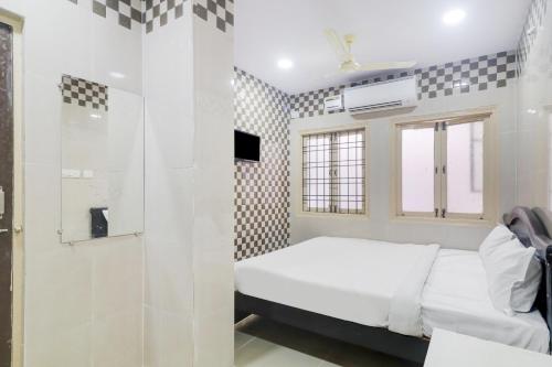 a small bedroom with a bed and a shower at OYO Hotel Aroma Classic Near Nampally Railway station in Hyderabad